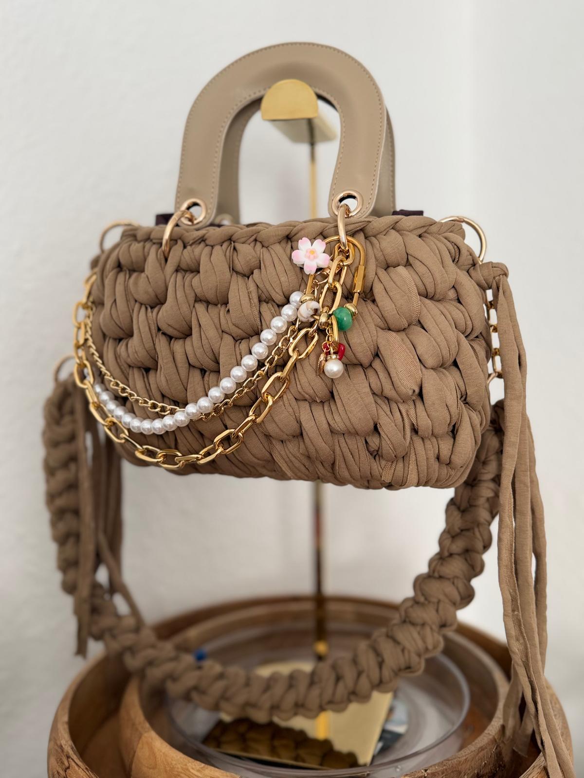 Taupefarbene Duduhook Tasche mit Perlenkette und kleinem Blumenanhänger